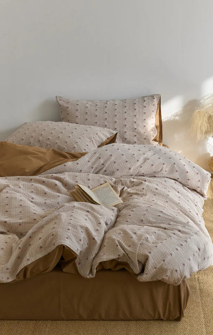 A comfortably messy bed with the Textured Ditsy Cherry Washed Cotton Bedding Set, emphasizing its cozy and lived-in feel - RoomDen.