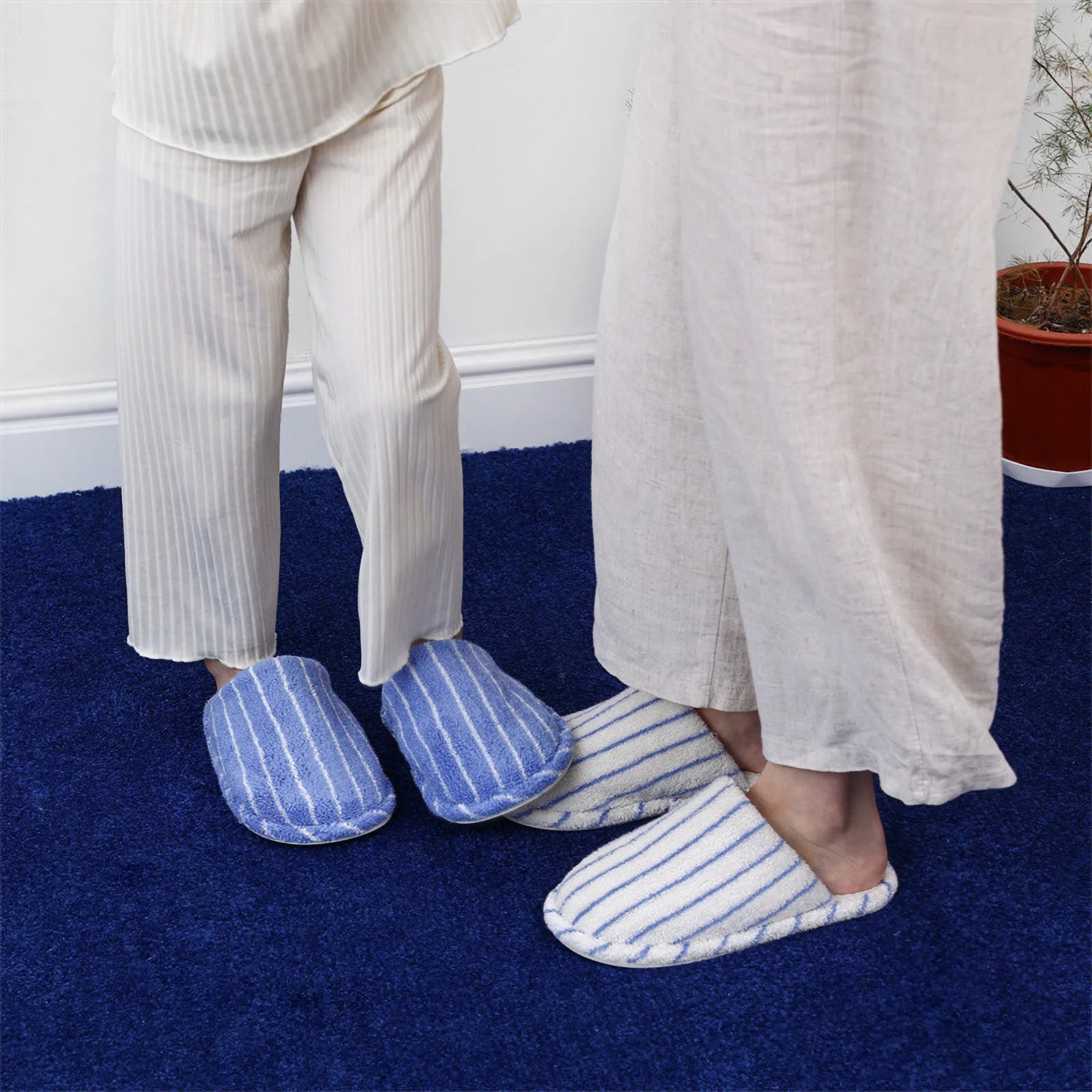 Lifestyle shot of person standing wearing Blue and White Striped cotton slippers