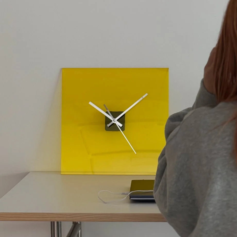 Close-up of the Zesty Yellow acrylic clock on a desk, showing its bright, clean face. - RoomDen
