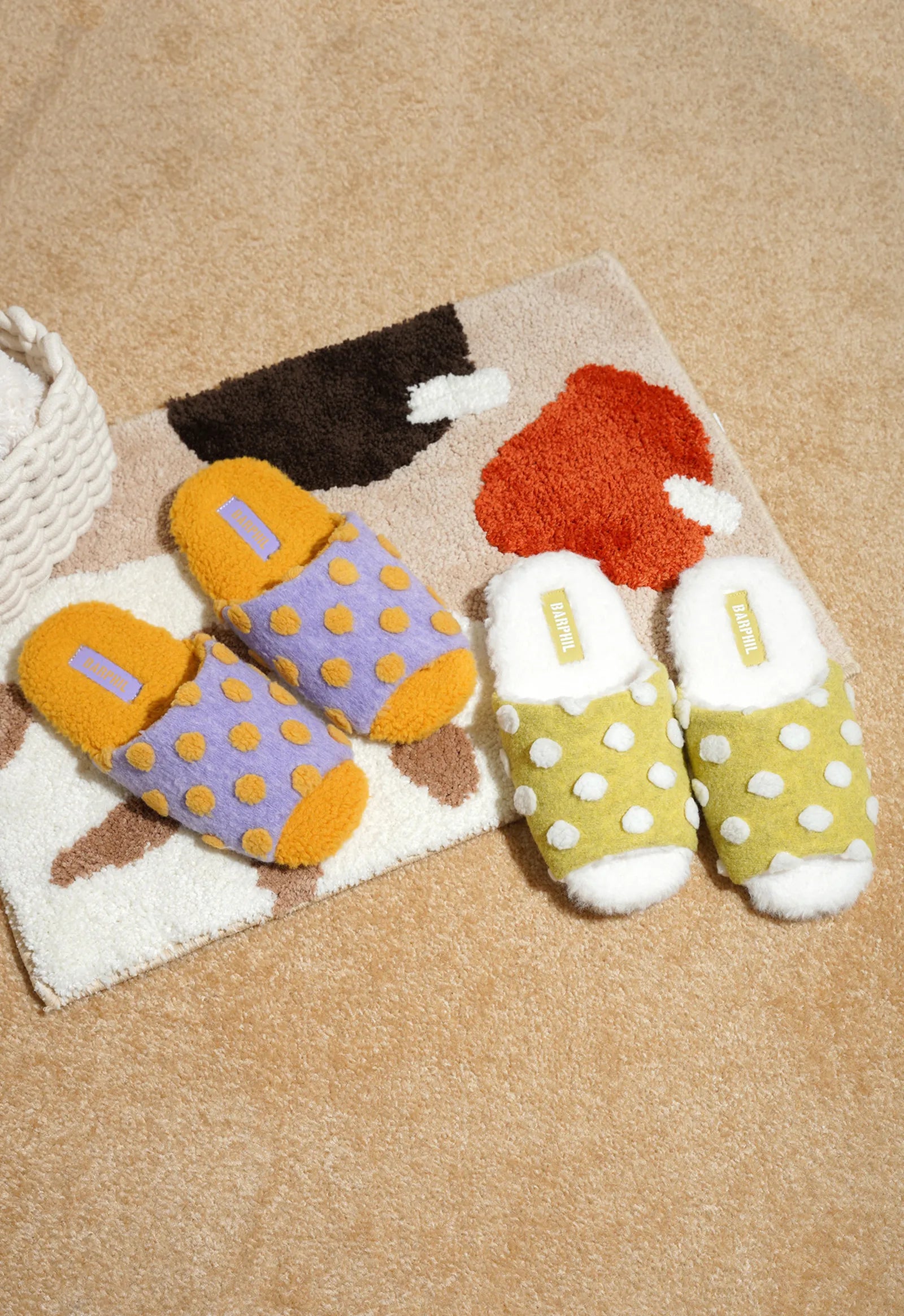 Flat lay of Purple and Green Polka Dot House Slippers on a patterned rug - RoomDen