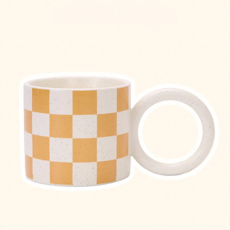 Angled view of the Orange Checkered Ceramic Mug with an Oversized Handle. - RoomDen