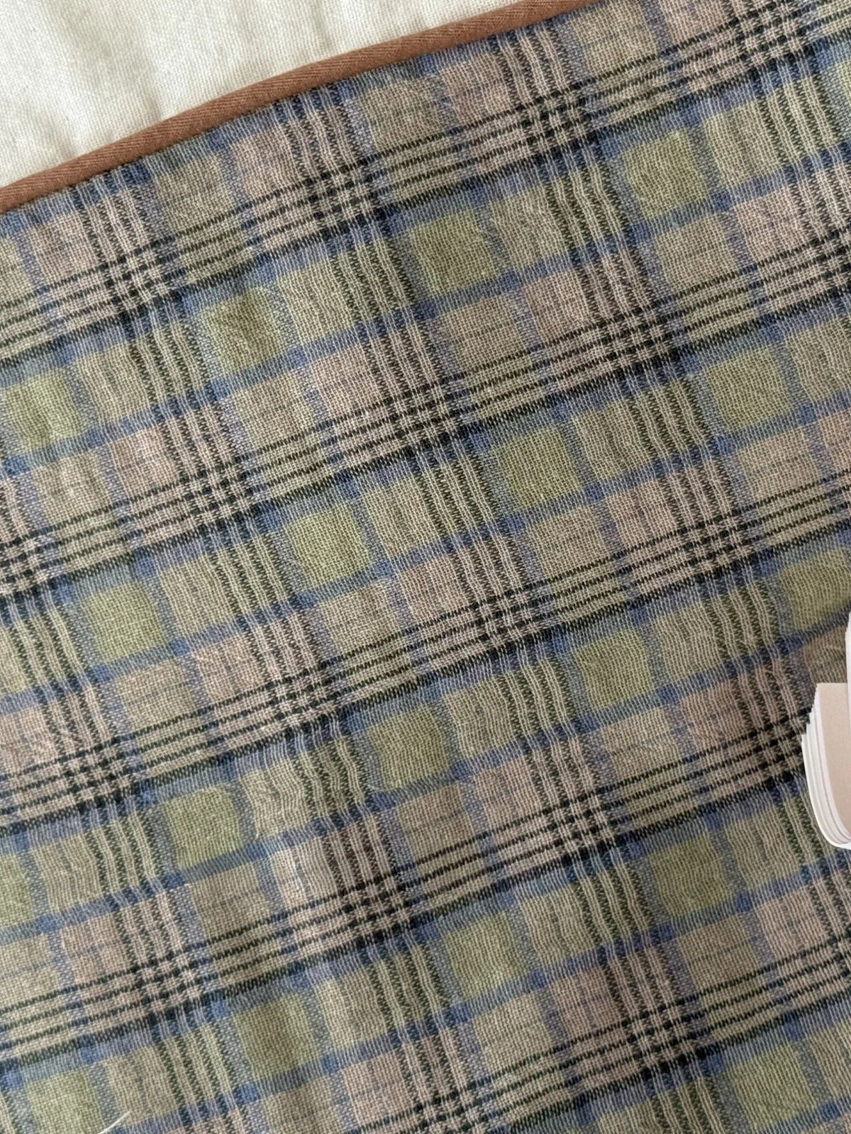 Close-up detail of the washed cotton plaid fabric, showing the texture and green, blue, and beige threads. - RoomDen