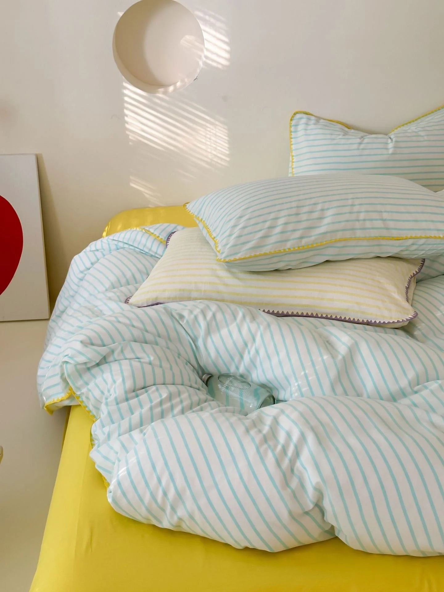 Detail of Blue Striped Pillowcase against Yellow Sheet - RoomDen