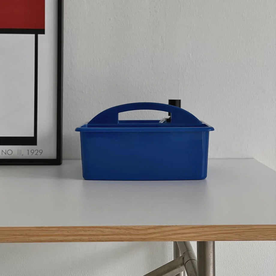 Blue portable organizer caddy sitting on a light wood and metal desk. - RoomDen
