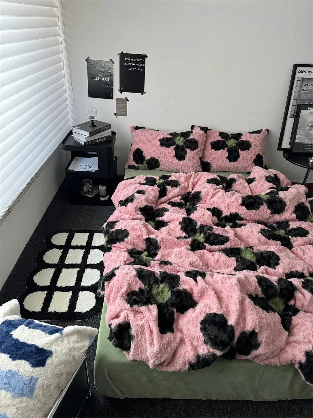 A styled bedroom featuring the pink and black abstract floral bedding set with a black and white checkerboard rug. - RoomDen