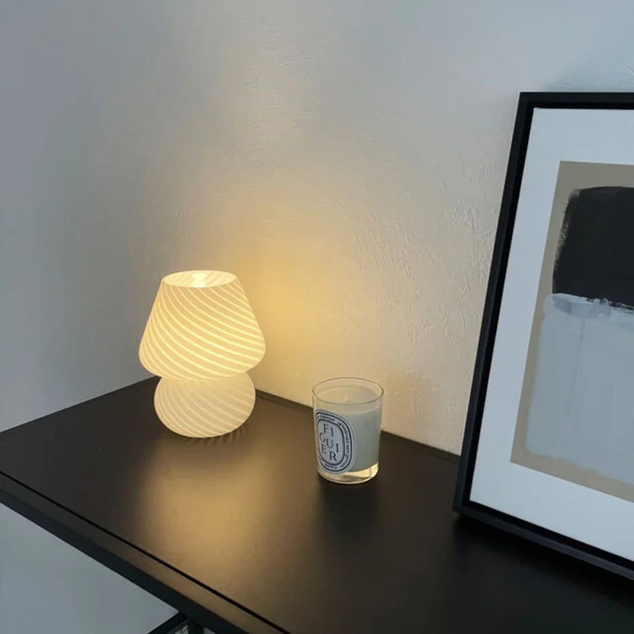 Angled view of the Swirled Glass Mushroom Lamp, showcasing its soft, ambient light in a minimalist setting.