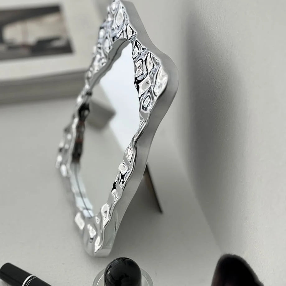Angled side view of the chrome desktop mirror, highlighting its unique, sculptural form - RoomDen
