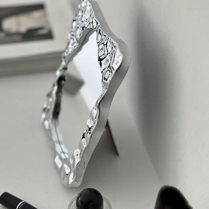 Angled side view of the chrome desktop mirror, highlighting its unique, sculptural form - RoomDen