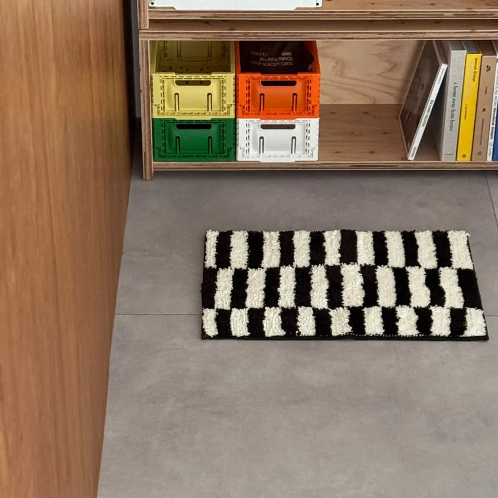 Black and white shaggy rug placed in a modern room with plywood furniture and colorful crates - RoomDen