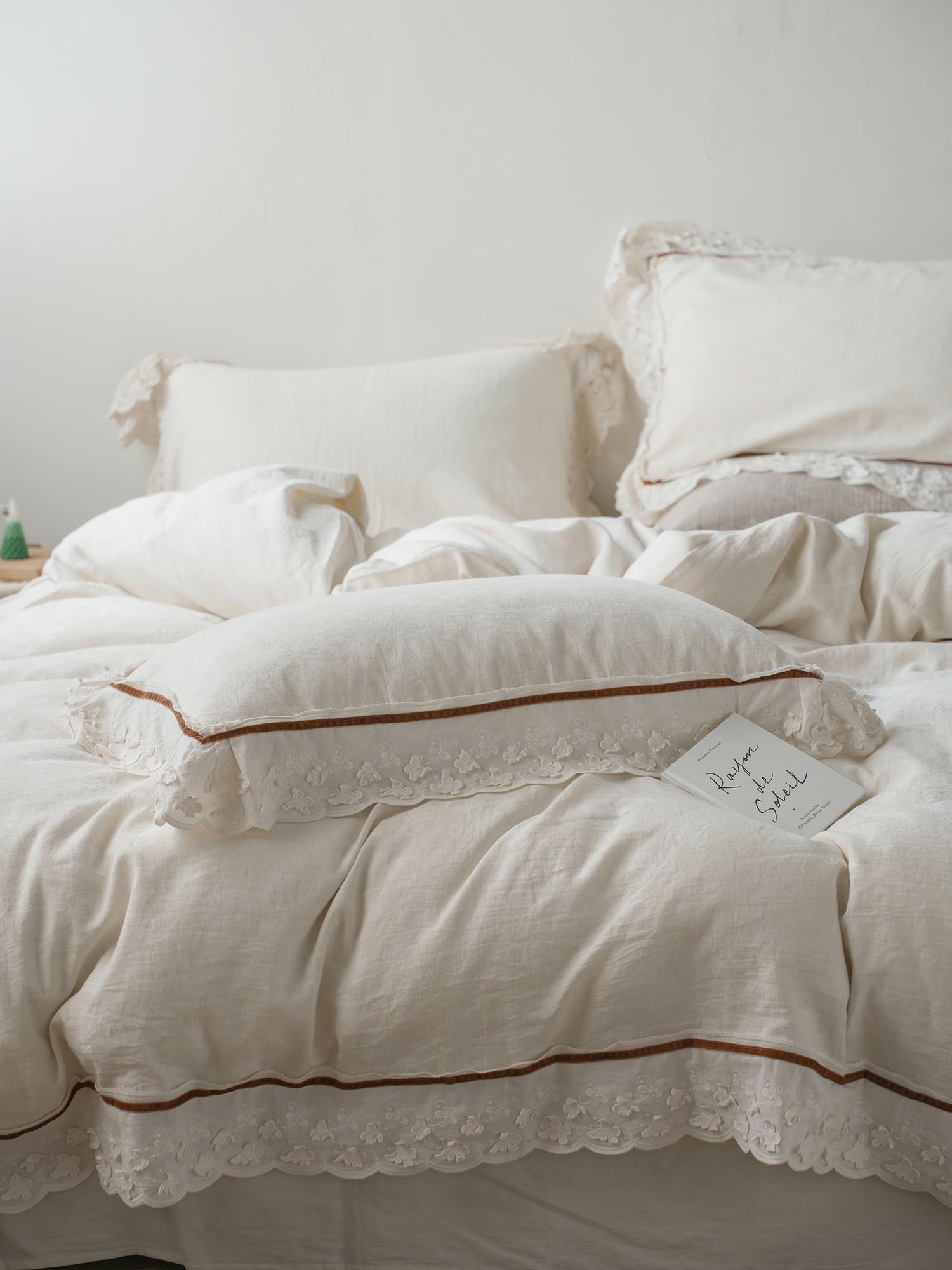 Close-up of scalloped lace linen pillow with contrast piping detail – RoomDen