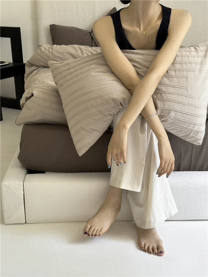 Minimalist textured stripe washed cotton pillowcase in soft neutral tones, styled in a calm cozy bedroom – RoomDen