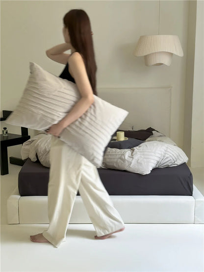Minimalist textured stripe washed cotton pillowcase in soft neutral tones, styled in a calm cozy bedroom – RoomDen