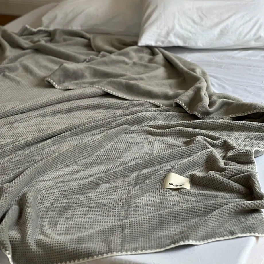 Soft waffle texture flannel fleece throw blanket in a minimalist cozy bedroom setting – RoomDen