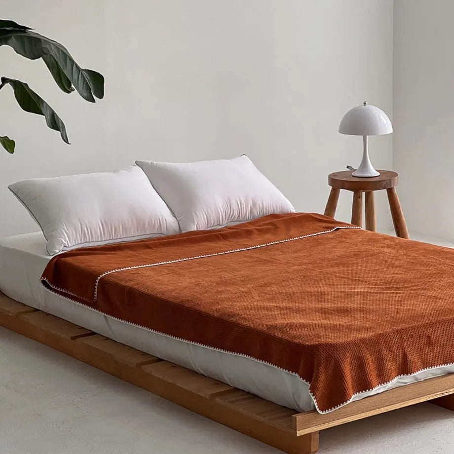Soft waffle texture flannel fleece throw blanket in a minimalist cozy bedroom setting – RoomDen