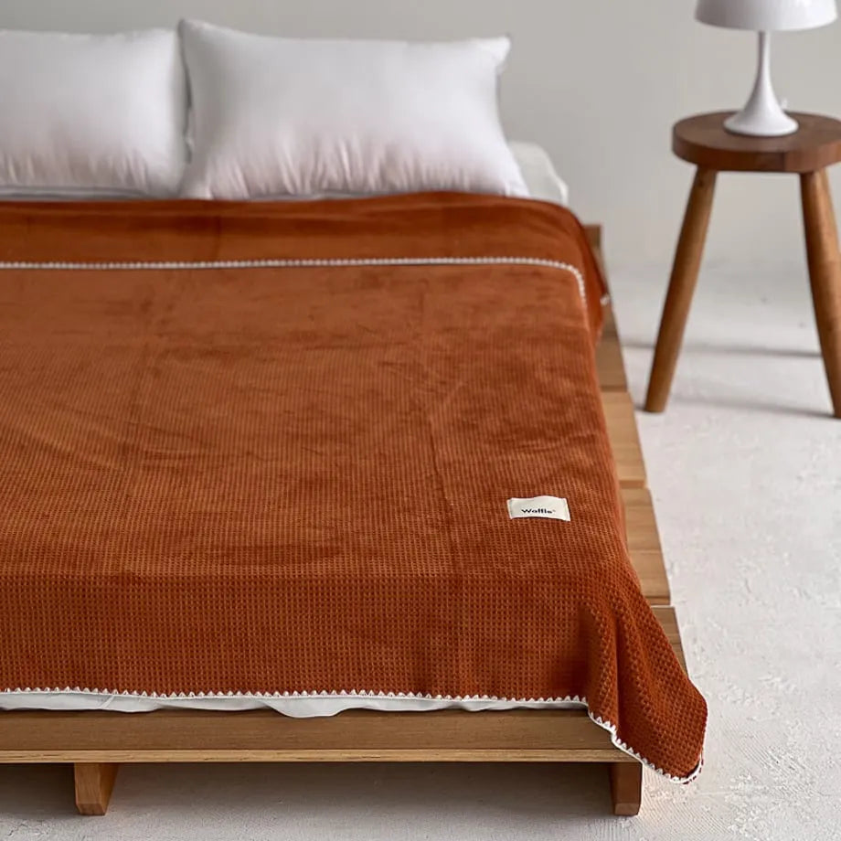 Soft waffle texture flannel fleece throw blanket in a minimalist cozy bedroom setting – RoomDen
