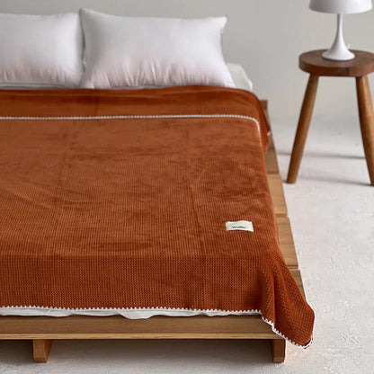 Soft waffle texture flannel fleece throw blanket in a minimalist cozy bedroom setting – RoomDen