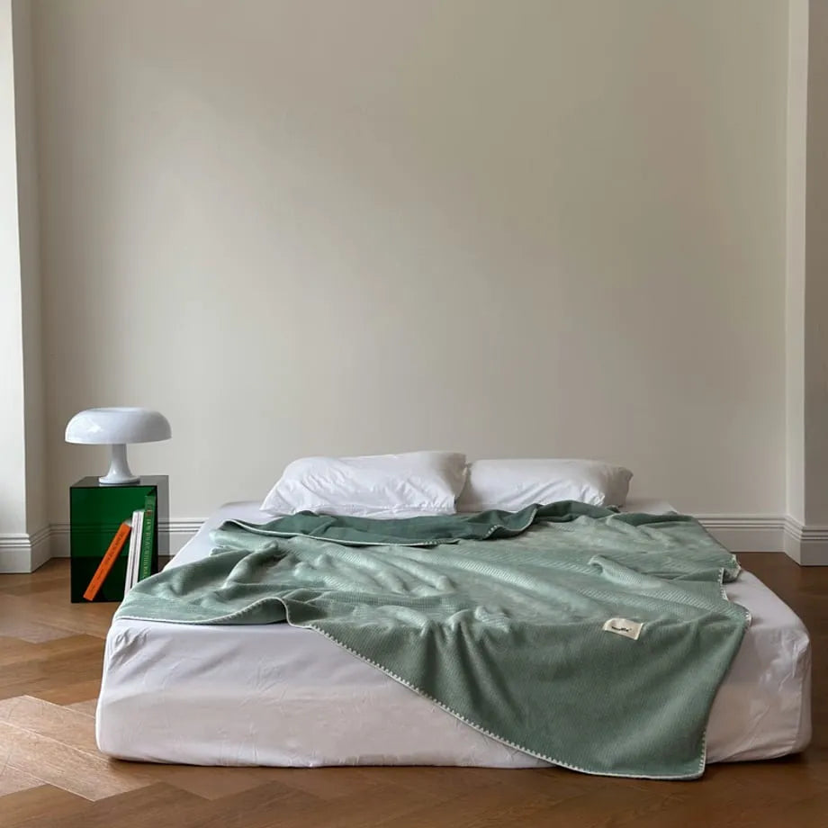 Soft waffle texture flannel fleece throw blanket in a minimalist cozy bedroom setting – RoomDen