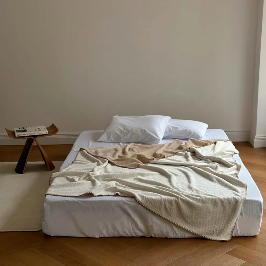 Soft waffle texture flannel fleece throw blanket in a minimalist cozy bedroom setting – RoomDen