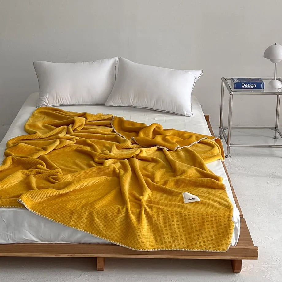 Soft waffle texture flannel fleece throw blanket in a minimalist cozy bedroom setting – RoomDen