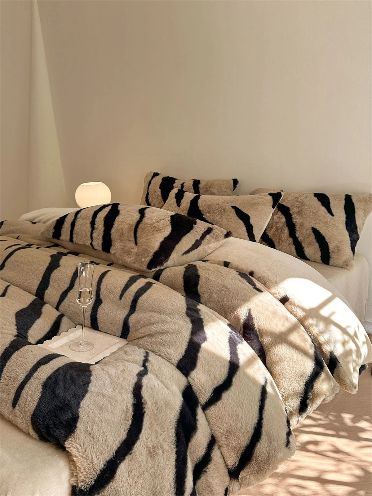 The Mocha Brown and Black Tiger Stripe Fleece Bedding Set, elegantly styled with a champagne glass on a tray. - RoomDen