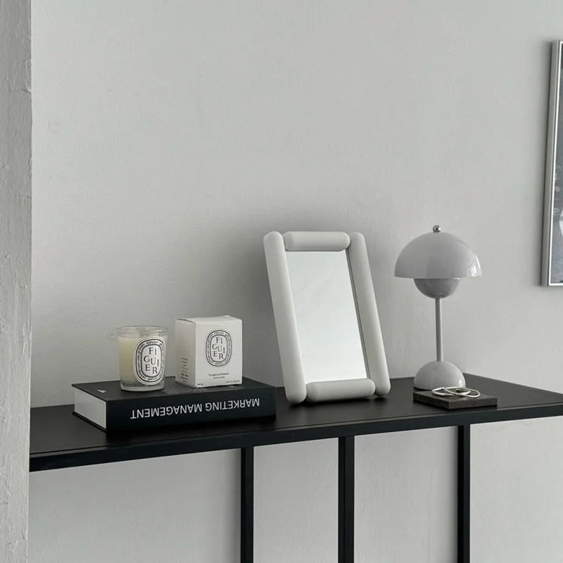 Lifestyle scene of the white rounded pill-shaped mirror on a console table — RoomDen