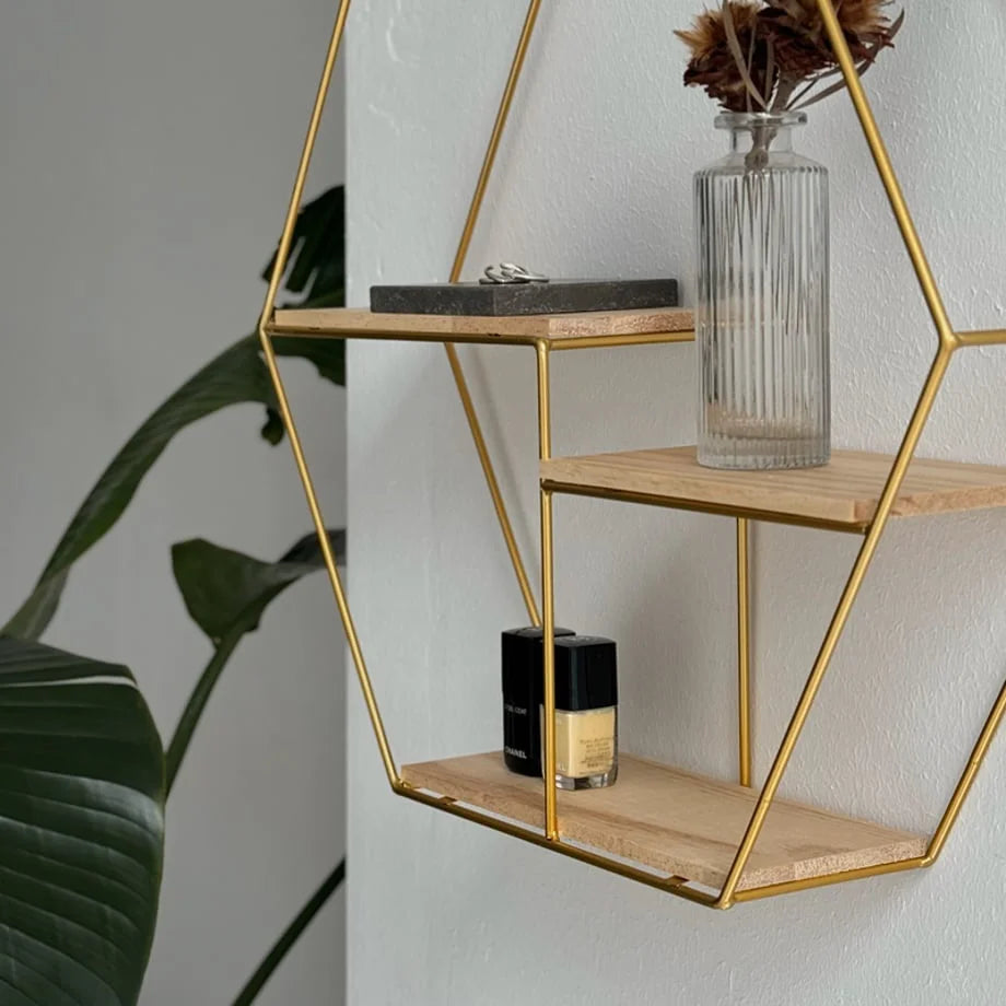Detailed view of the gold metal frame and light wood shelves on the Hexagon Wall Shelf - RoomDen