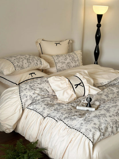 Full view of the Cream Toile bedding set on a bed with a book and candle, highlighting the Coquette aesthetic. - RoomDen