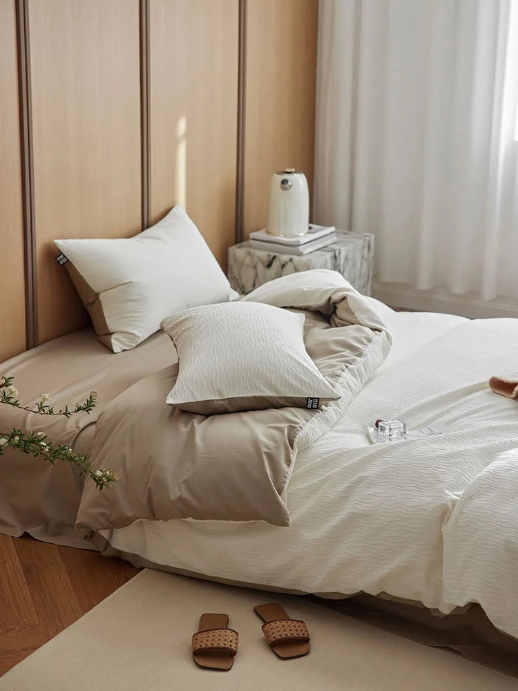 Close-up of the Cream White Wavy Textured pillow and duvet cover against a beige sheet. - RoomDen