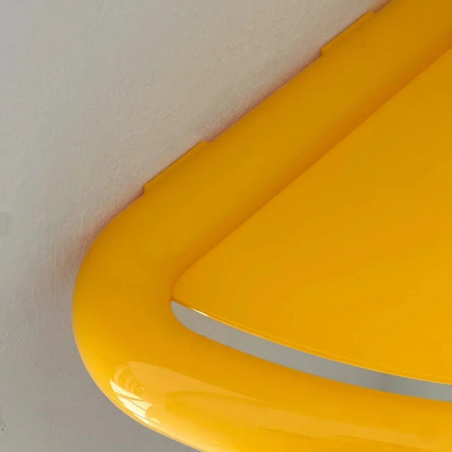 Macro shot of the glossy, rounded edge and vibrant yellow color of the ABS plastic corner shelf. - RoomDen