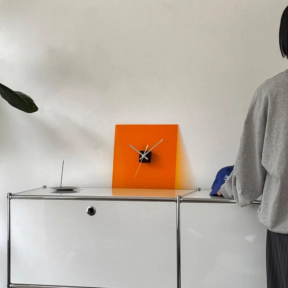 Sleek Solid Color Acrylic Table Clock in Vivid Orange sitting on a white and chrome cabinet. - RoomDen