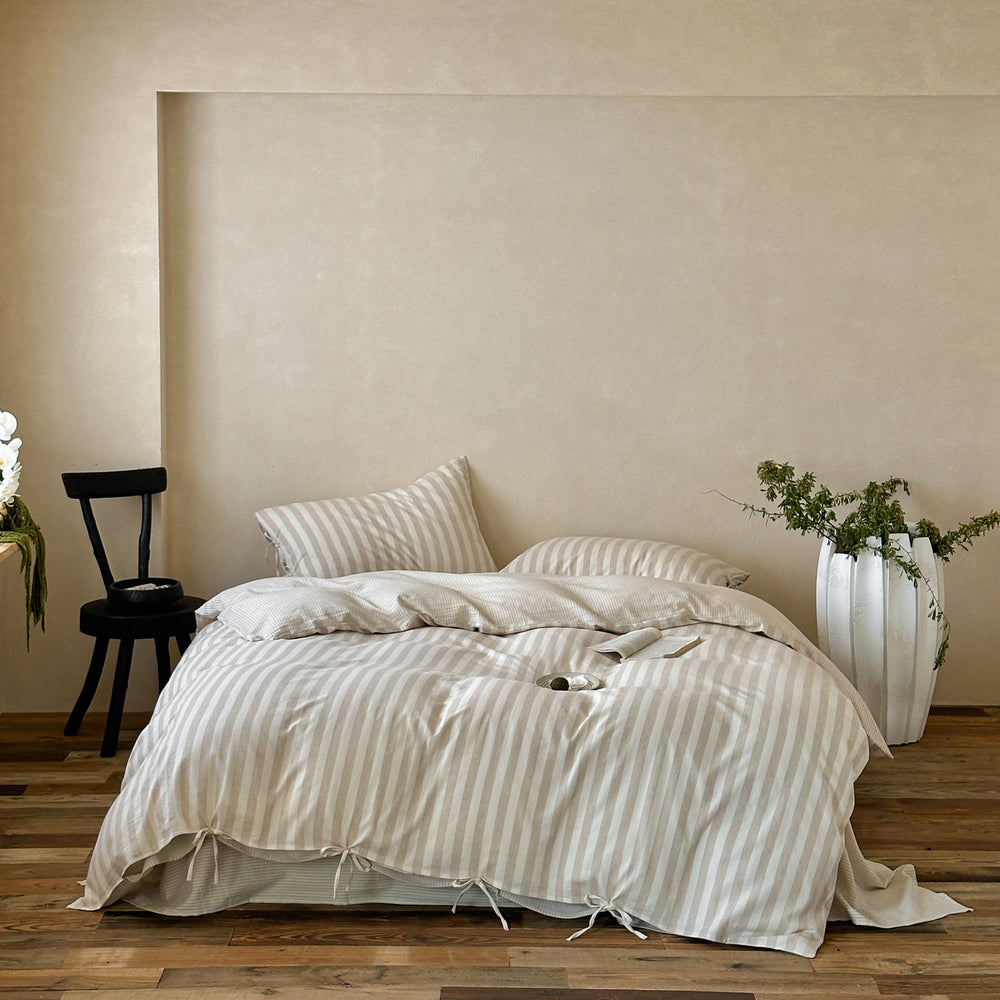 Ashfield Oat Stripe Bedding Set – Wide view of oat striped bedding against a pale wall - Roomden