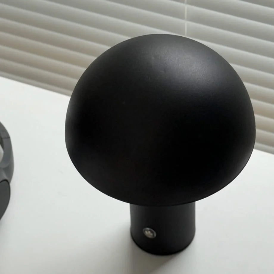 Top-down view showing the smooth, matte dome of the black mushroom accent lamp - RoomDen.