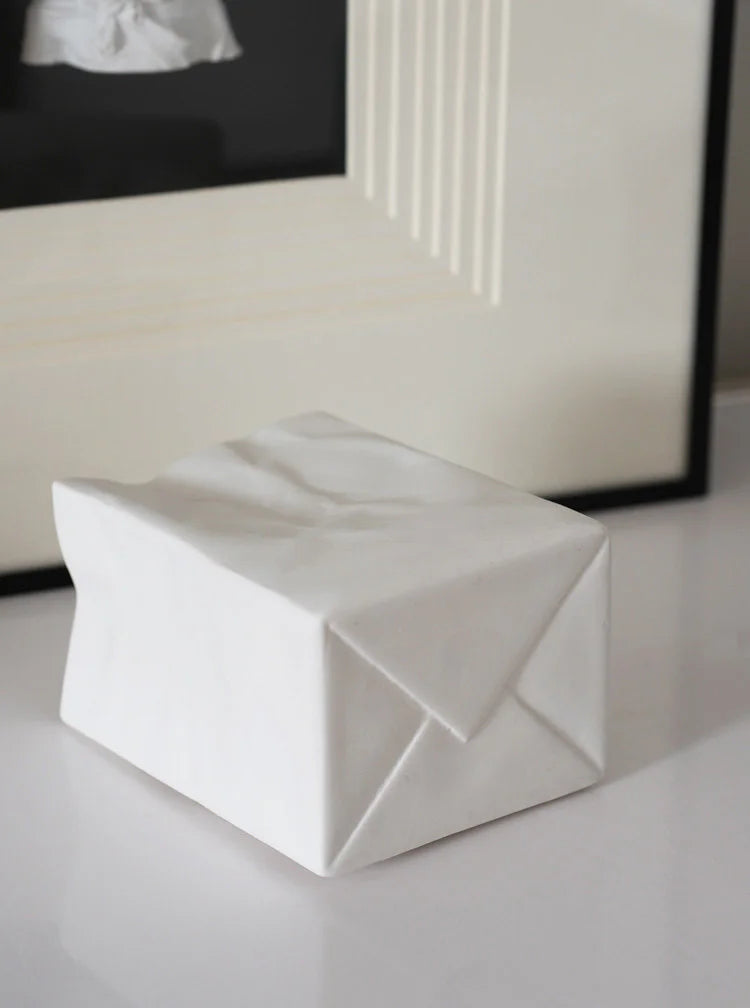 A white crumpled ceramic organizer shown with its bottom folded detail, resembling a paper bag. - RoomDen