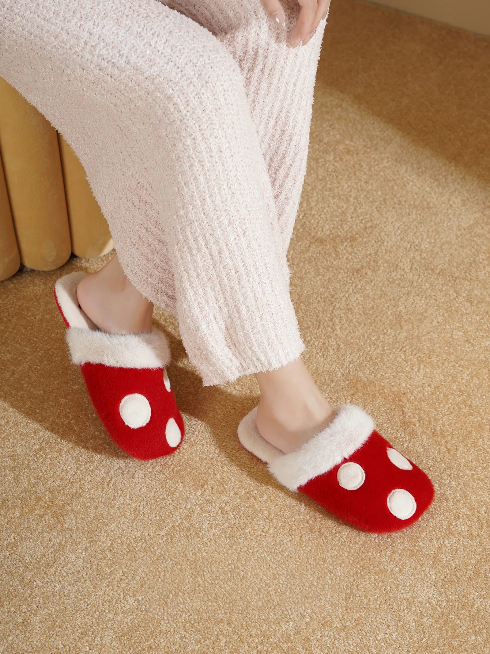 Side view of red polka dot plush slippers on feet - RoomDen