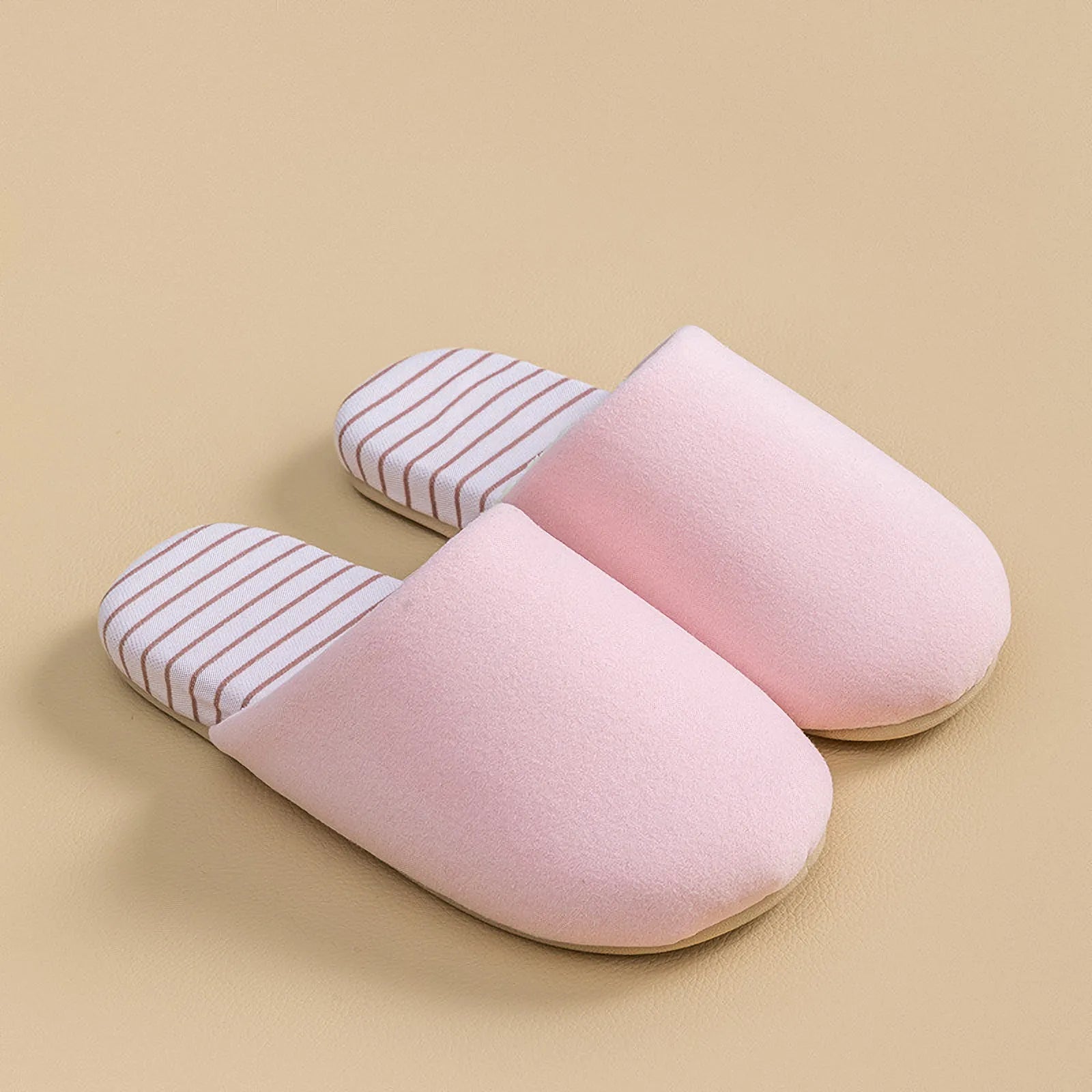Top down view of pink cotton house slippers isolated on beige background