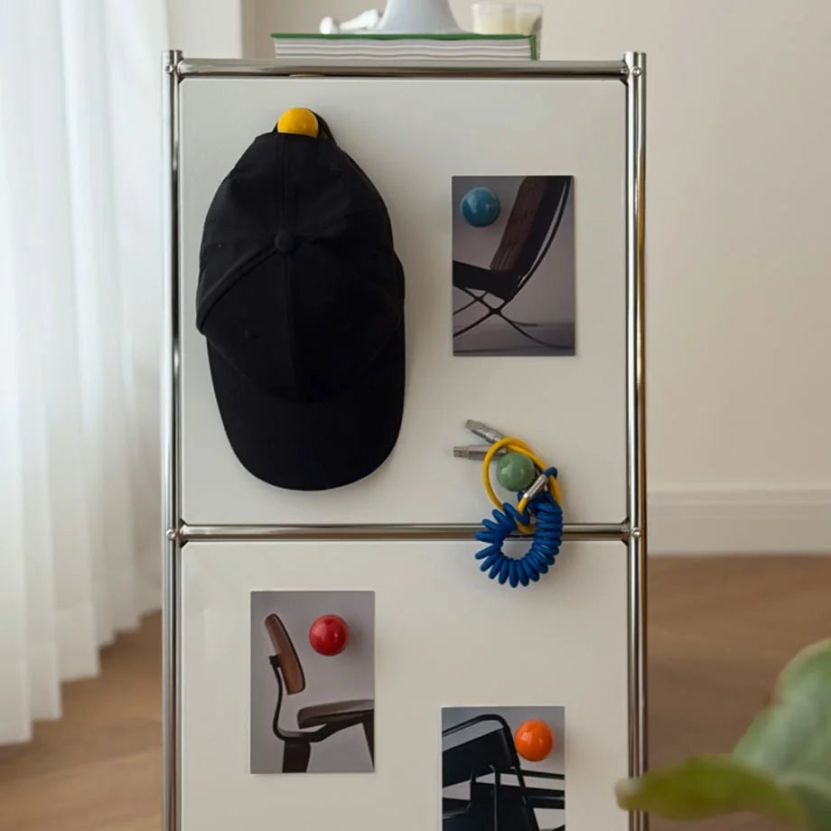 Full view of colorful magnetic hooks organizing items on a modern white cabinet. - RoomDen