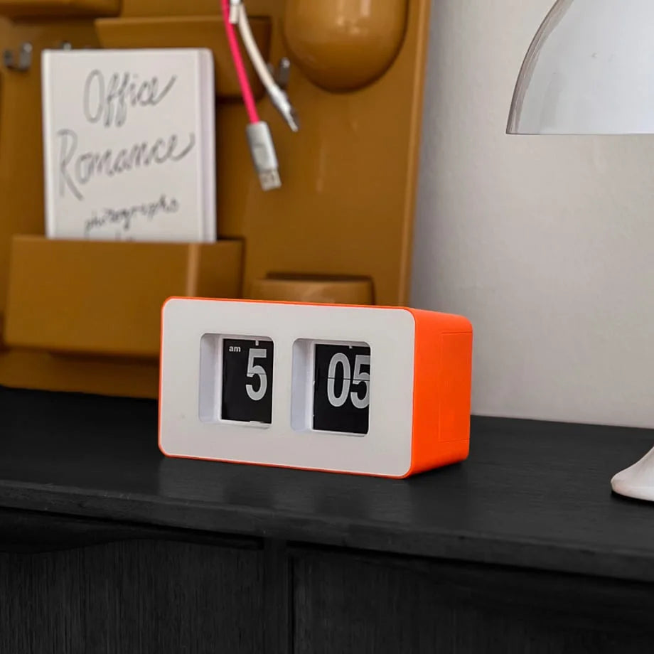 Close-up of the orange and white retro flip table clock showing 5:05 AM. - RoomDen