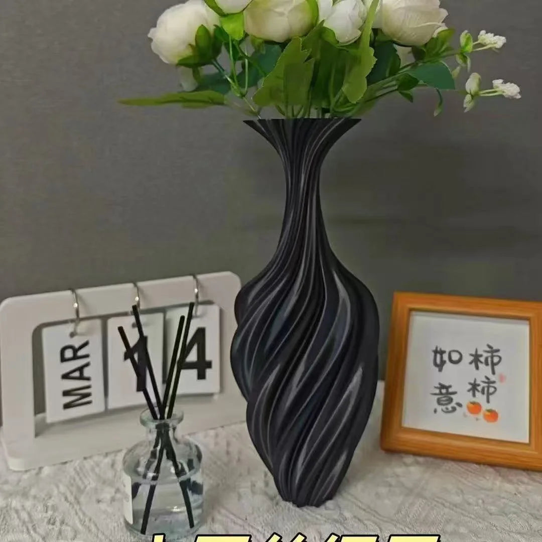 Matte Black Sculptural Swirl Vase holding white flowers on a desk with a calendar and diffuser - RoomDen