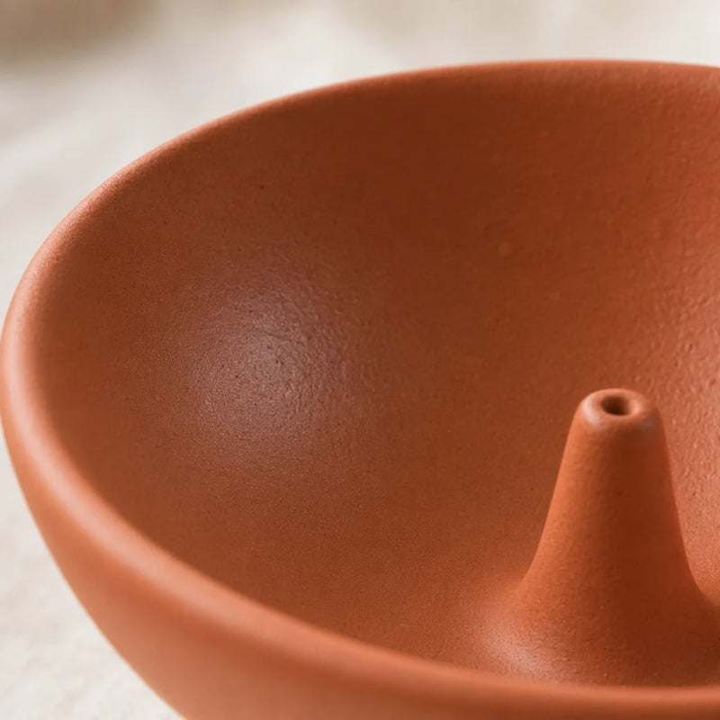 Macro detail of the ceramic incense holder glaze showing the kept thumb-dent near the rim — RoomDen