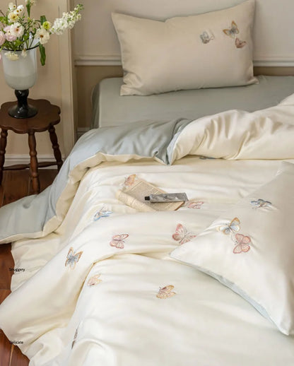 Detailed shot of the corner of the duvet cover, showing the delicate butterfly embroidery.
