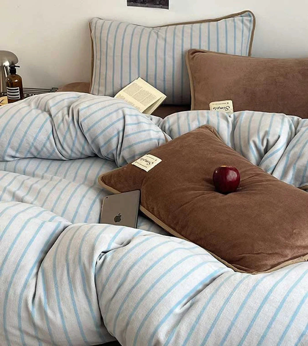 Angled shot of the plush Mocha Brown flannel fleece pillowcases and striped duvet cover. - RoomDen