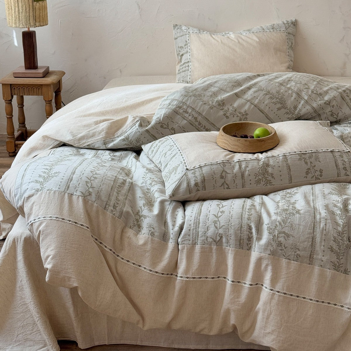 Meriwyn Botanical Linen-Cotton Bedding Set – botanical duvet folded over a natural-coloured sheet beside a wooden chair - Roomden
