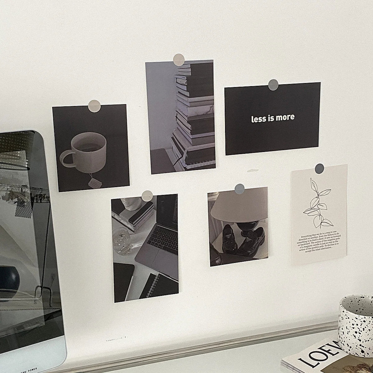 Monochrome wall collage kit artfully displayed on a dorm room wall next to a computer monitor. - RoomDen