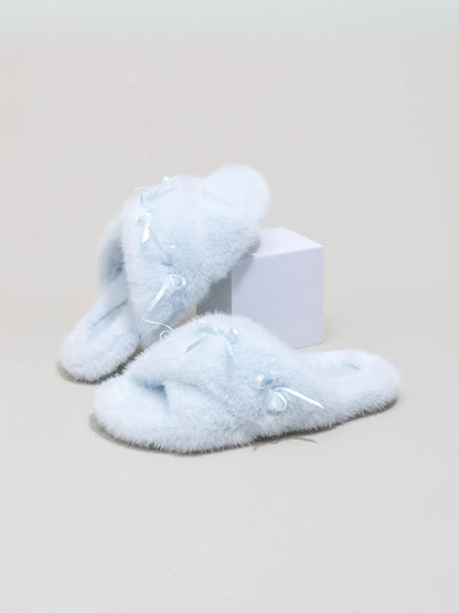 Pair of baby blue fluffy slides with bows on a white display block - RoomDen