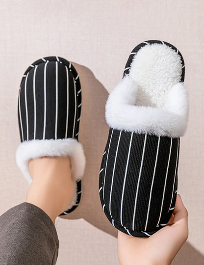 Hand holding a Black and White striped slipper showing sole flexibility - RoomDen
