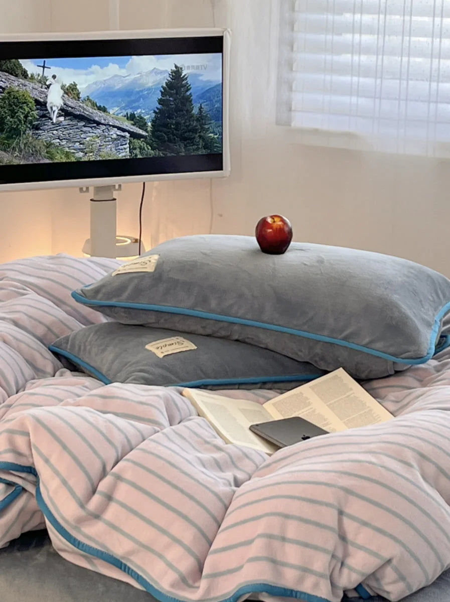 Close-up of the Slate Grey flannel fleece pillowcases and striped duvet cover in a softly lit room. - RoomDen