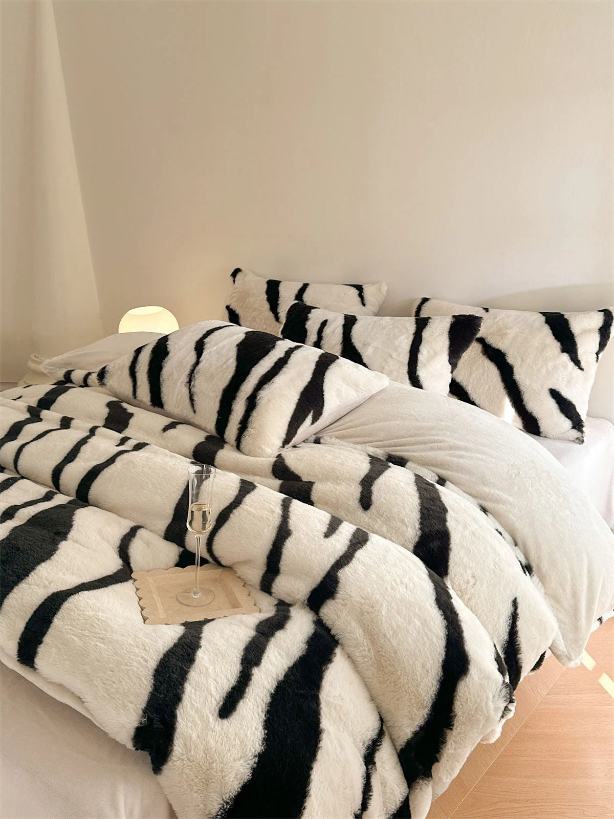 The Classic White and Black Tiger Stripe Fleece Bedding Set on a bed, showcasing its bold, high-contrast design. - RoomDen