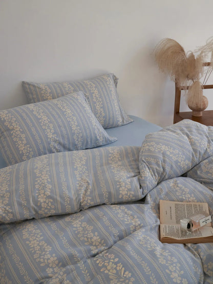Full view of the bed with the floral stripe washed cotton bedding, showing its soft, rumpled texture. - RoomDen