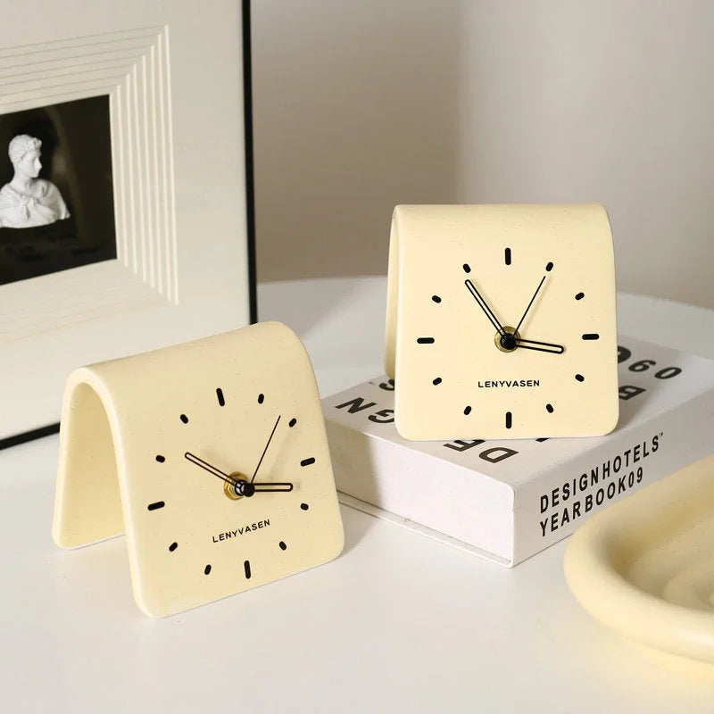 Two Butter Yellow Matte Arch Ceramic Table Clocks on a white desk with books - RoomDen
