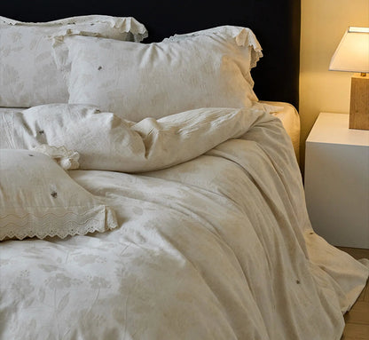 Lifestyle image of the Antique White linen bedding set in a cozy bedroom with a bedside lamp on - RoomDen
